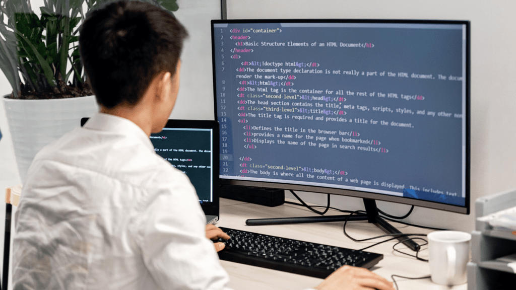 A person in a white shirt is working on a computer