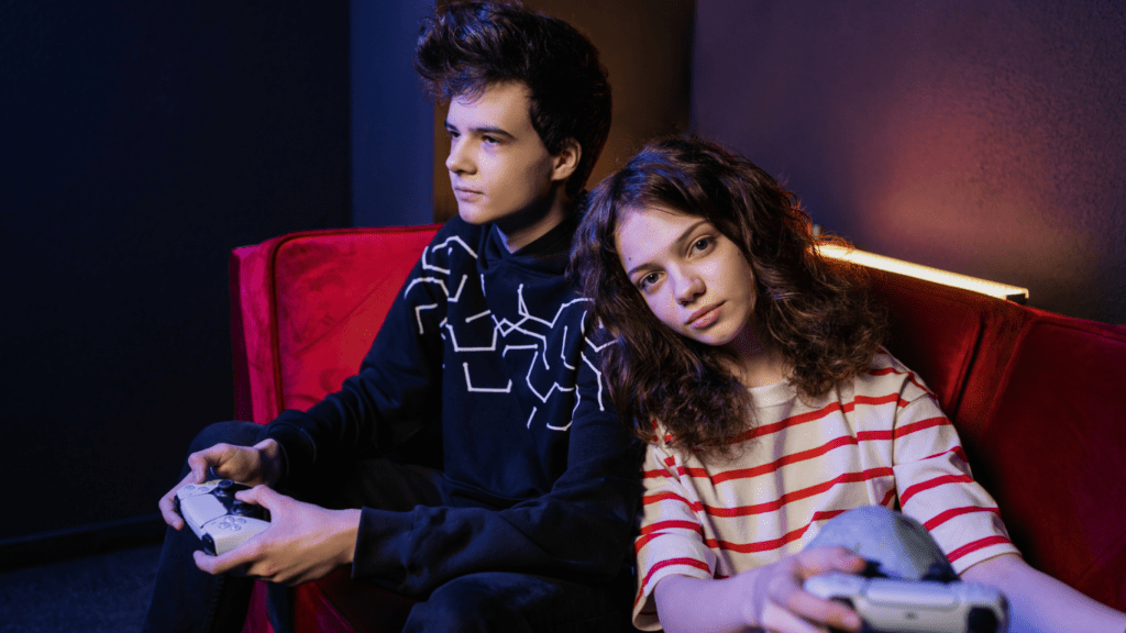 a person holding a video game controller in front of a neon sign