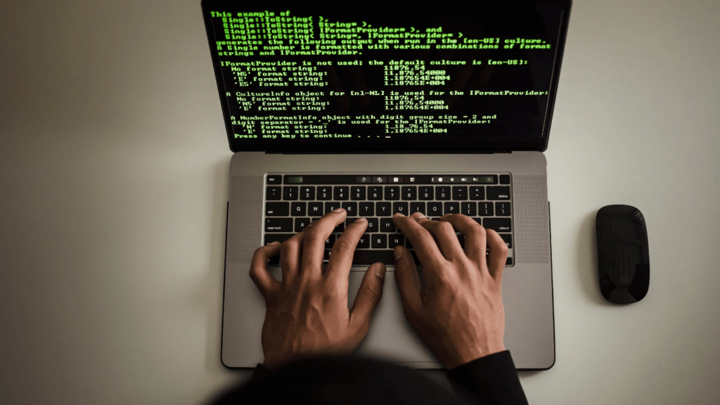 a person typing on a laptop with code on the screen