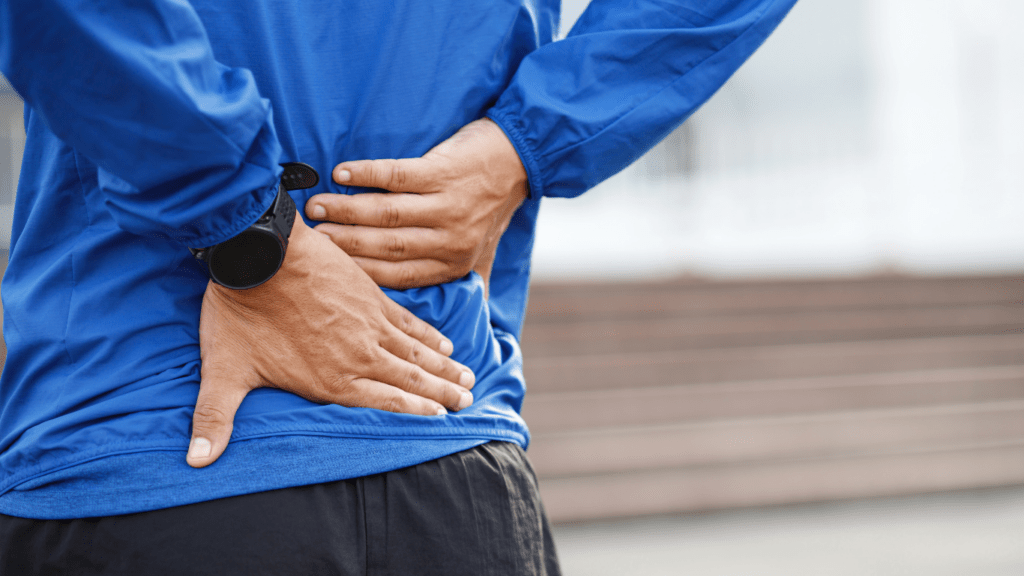 a person with back pain sitting at a desk