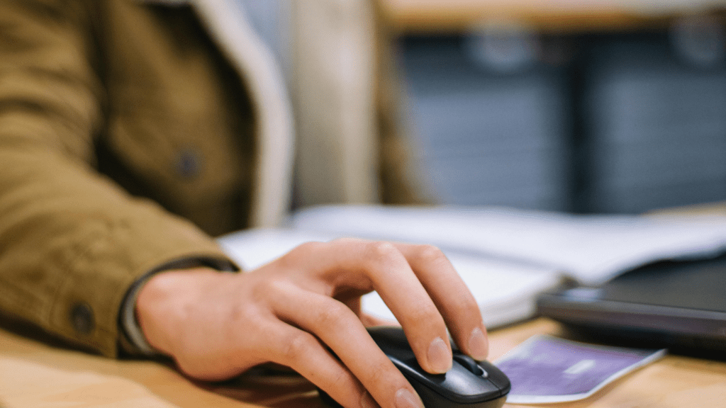 a person using a mouse on a laptop computer
