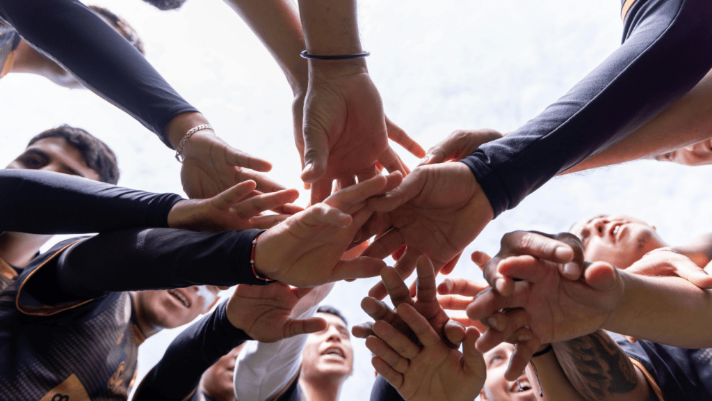 a group of people putting their hands together in a circle