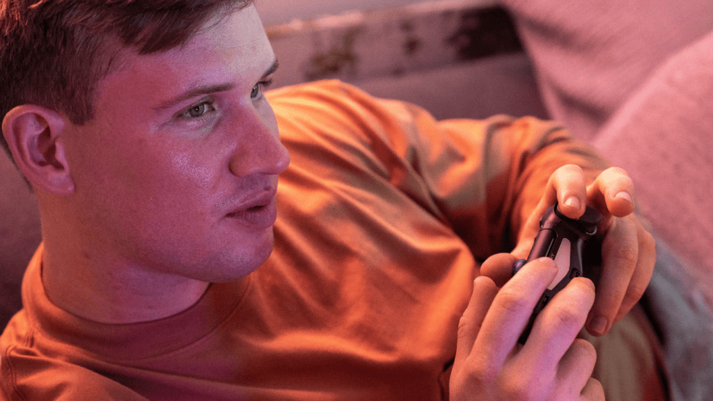 a boy sitting on a couch holding a video game controller