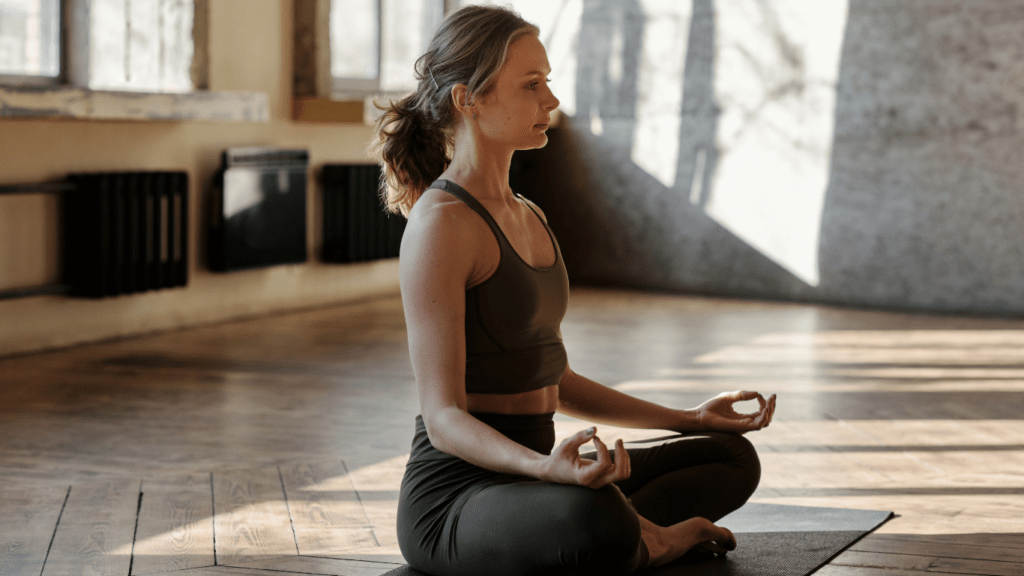 a person meditating in a yoga pose on a mat