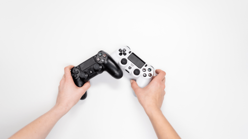 a person holding a video game controller in front of a white wall