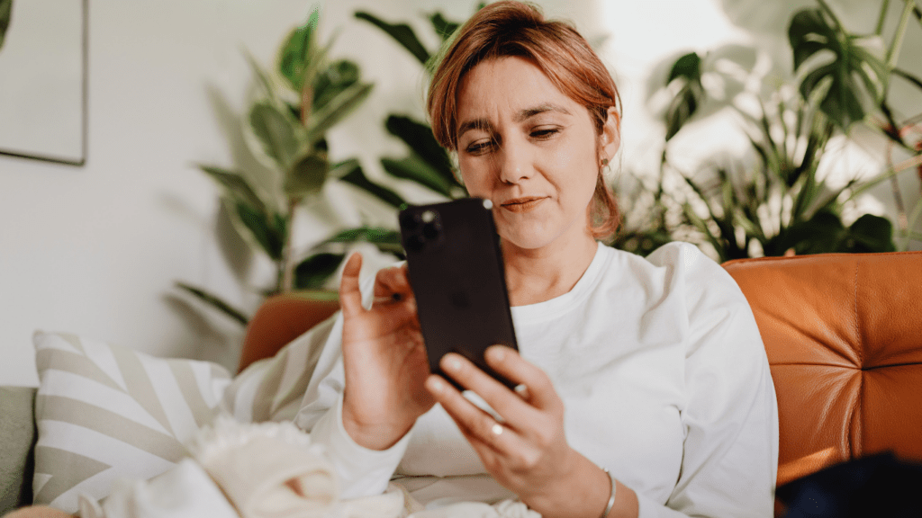 a person sitting on a couch holding a cell phone