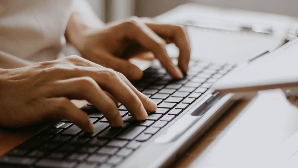 close up of a person typing on a laptop