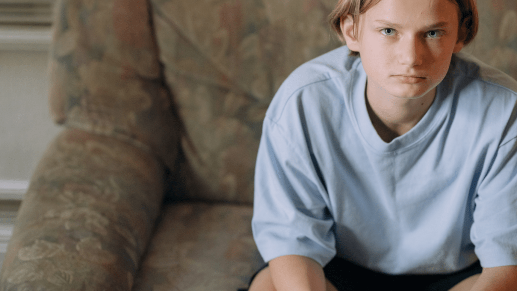 a boy sitting on a couch holding a video game controller