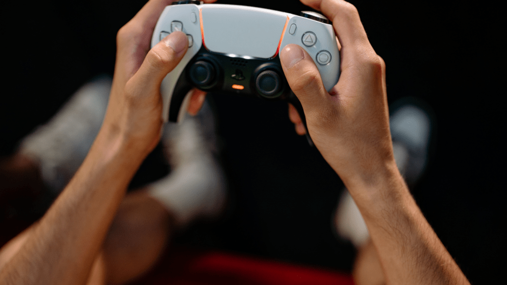 a close up of someone's hands holding a video game controller