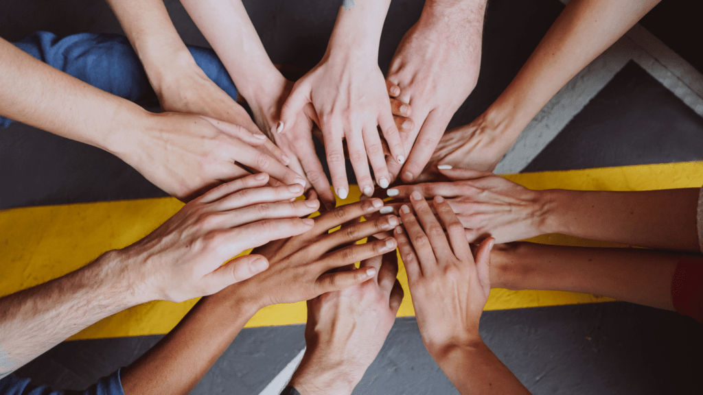 a group of people putting their hands together in a circle