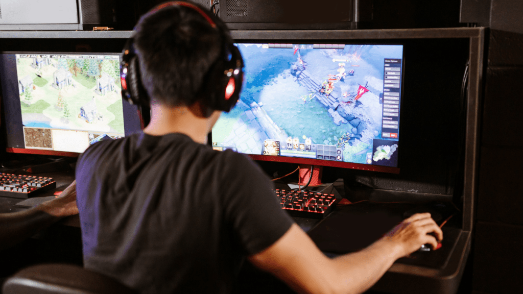 a person is playing video games on two monitors