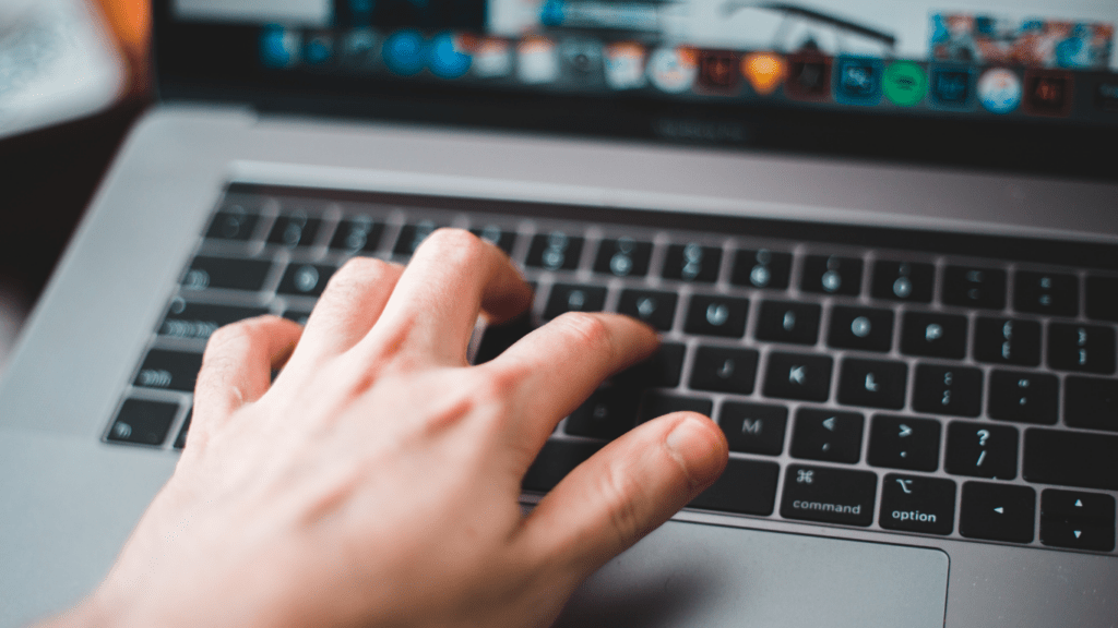 a person is typing on a laptop computer