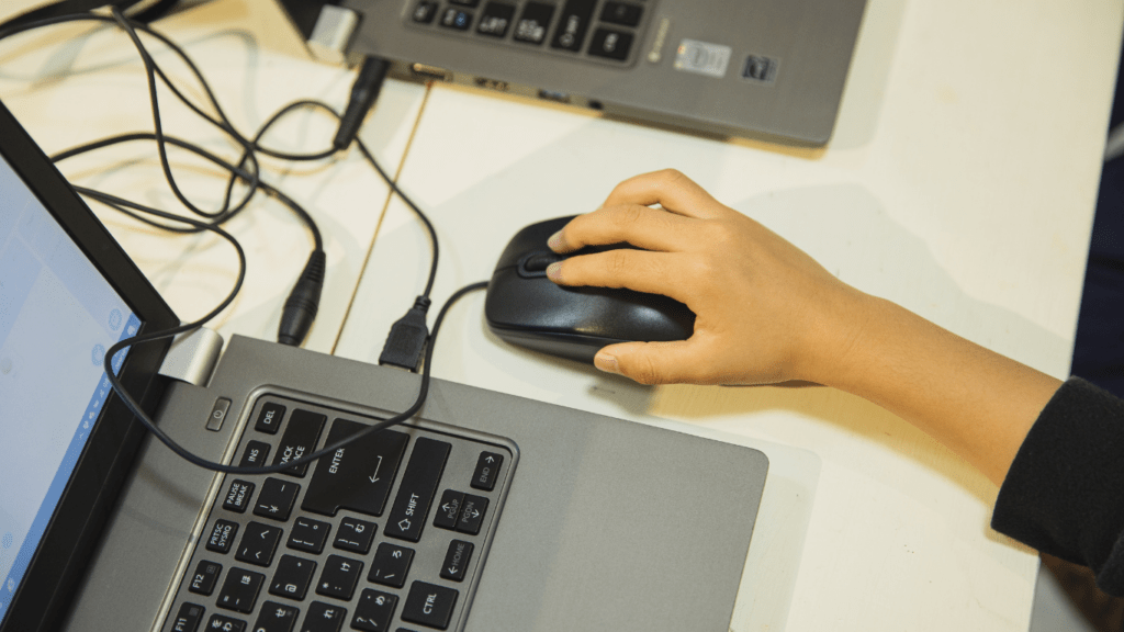 a person using a mouse on a laptop computer