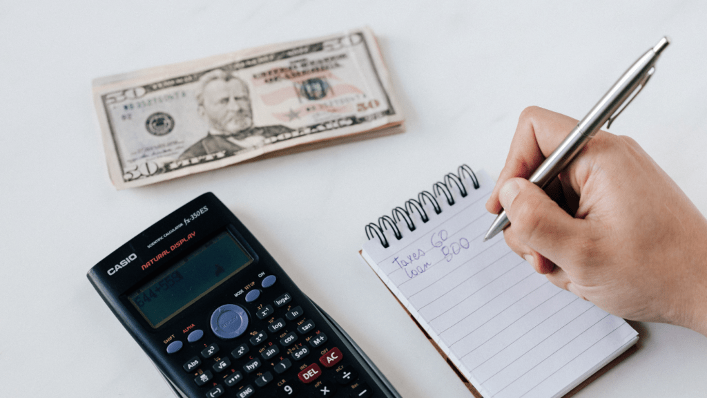 calculator, pen, money and notepad on white table