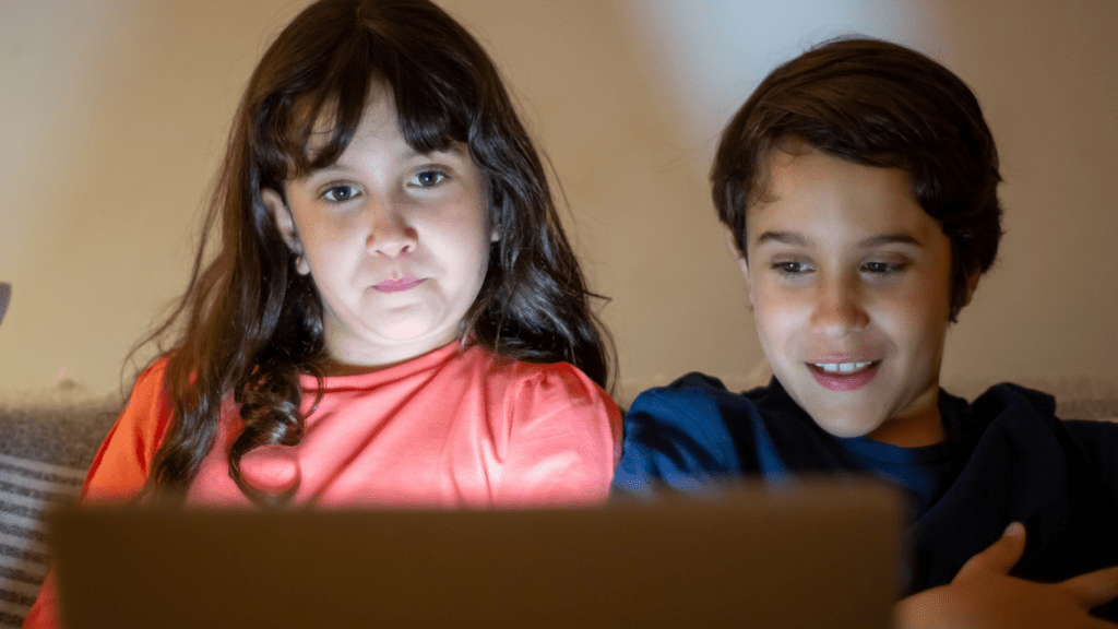 children sitting on a couch with a laptop