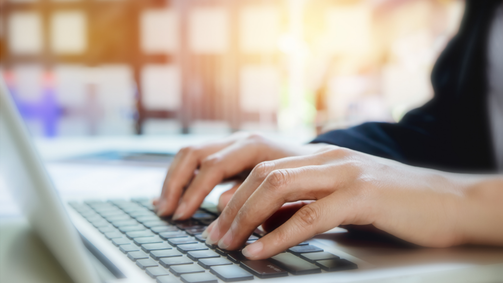 close up of a person typing on a laptop