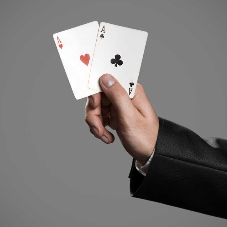 A Businessman Holding An Aces On Gray Background. Ace In The Hol