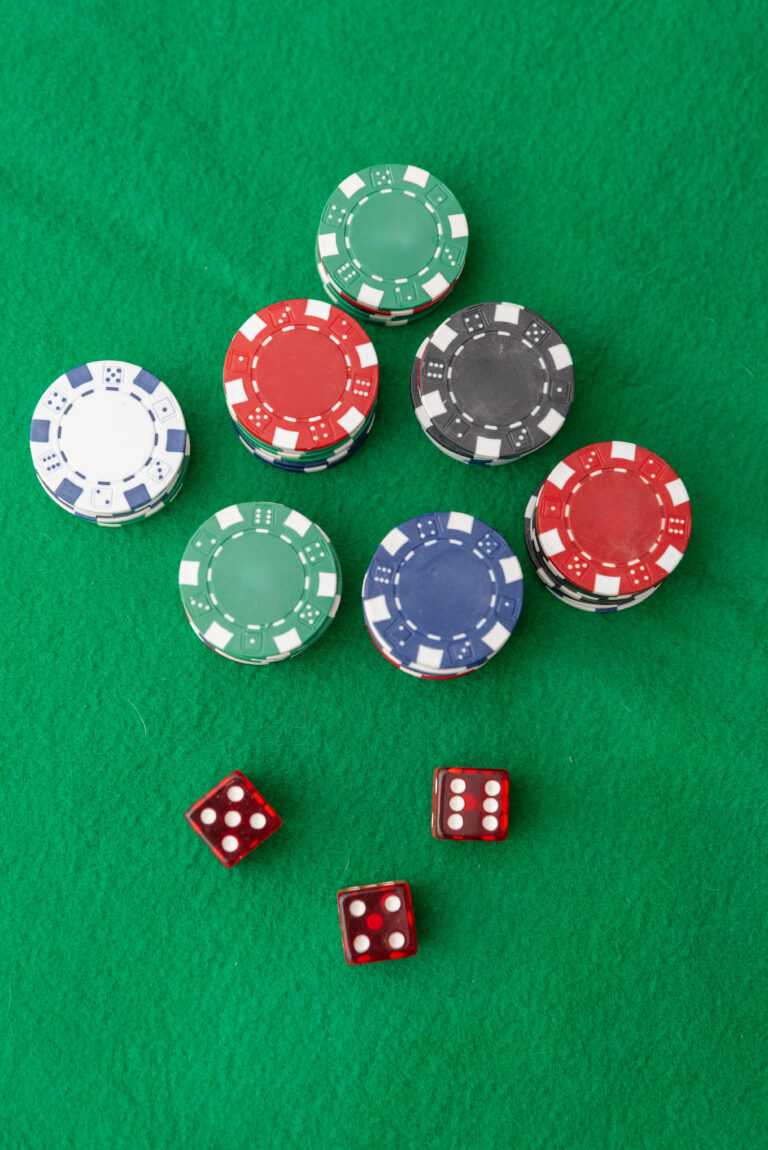 Stacks of poker chips and dice on green felt table